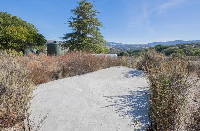 a view of a dry yard with wooden fence