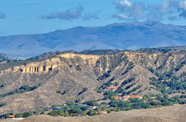 a view of a dry yard with wooden fence