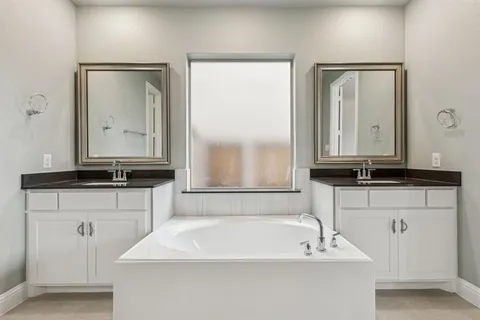 a bathroom with a tub sink and mirror