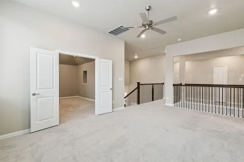 an empty room with windows and fan