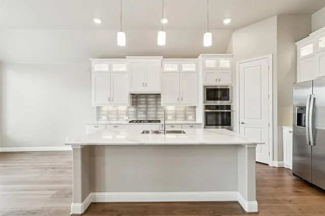 a large kitchen with kitchen island a sink stainless steel appliances and cabinets