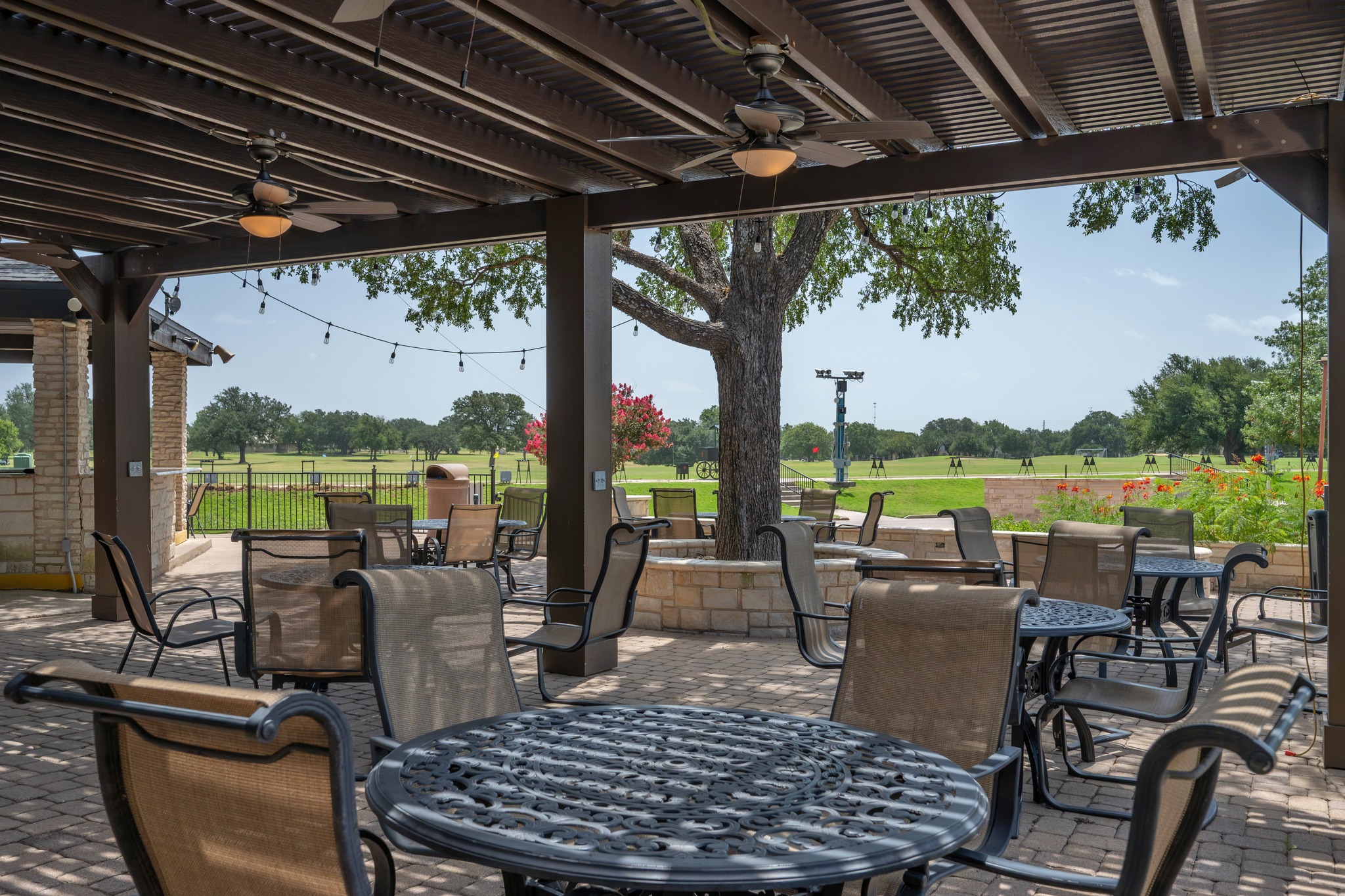 30115 Sawgrass Trail Georgetown, TX 78628 - Photo 33 of 37 An inviting outdoor patio, complete with comfortable seating and cooling fans, overlooks a verdant golf course.