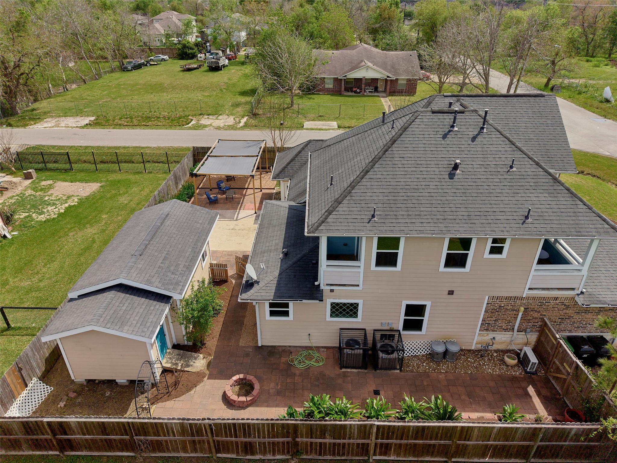 4219 Redbud Street Houston, TX 77051 - Photo 25 of 25 This photo showcases a spacious two-story home with a well-maintained exterior, featuring a large backyard with a patio and a separate outbuilding. The fenced yard offers privacy, and there's ample outdoor space for entertaining or relaxation.