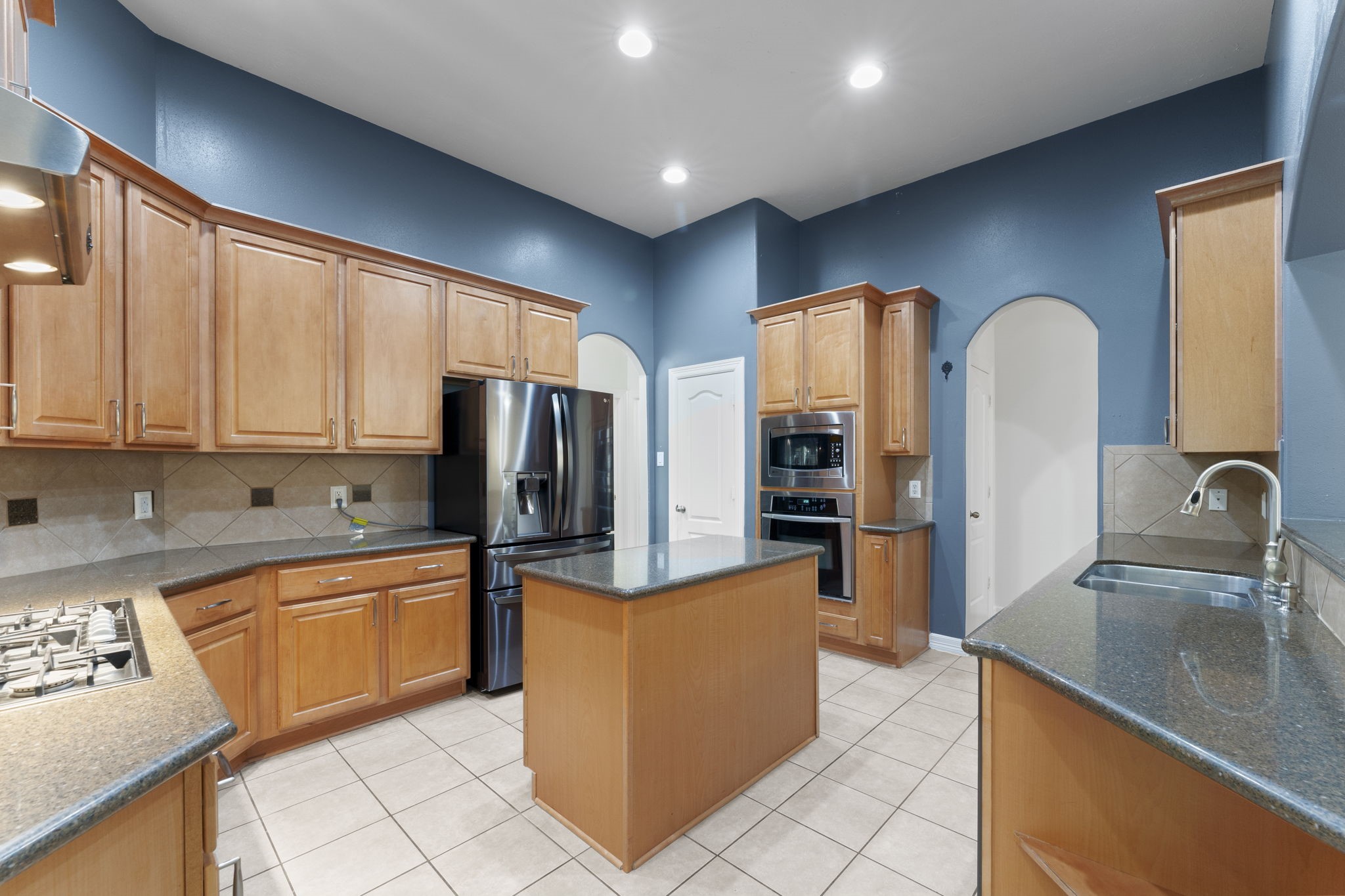 3131 Rustic Gardens Drive Spring, TX 77386 - Photo 15 of 39 a kitchen with stainless steel appliances granite countertop a sink refrigerator and cabinets