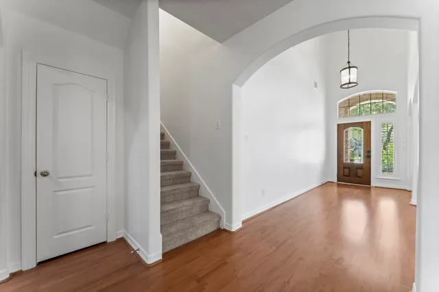 an empty room with wooden floor and entryway