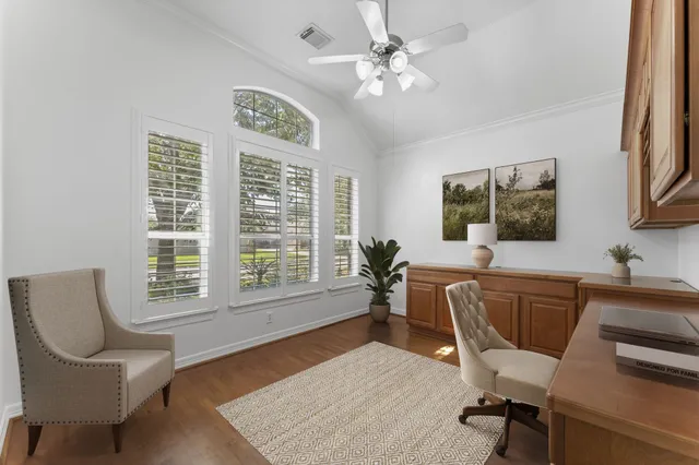 a living room with furniture two window and wooden floor