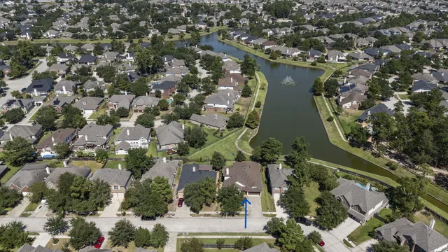 an aerial view of a residential houses with outdoor space and trees