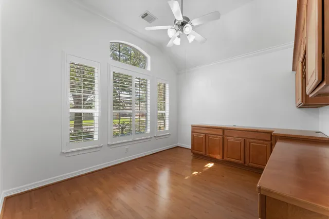 a view of an empty room with a window and wooden floor