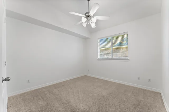 an empty room with a window and a fan