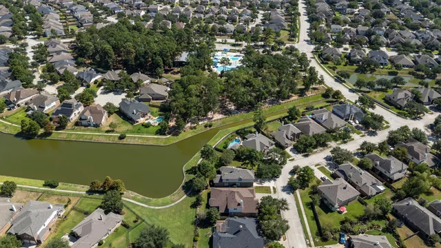 an aerial view of a house with a yard and lake view