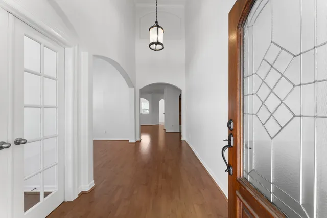 a view of a hallway with wooden floor and staircase