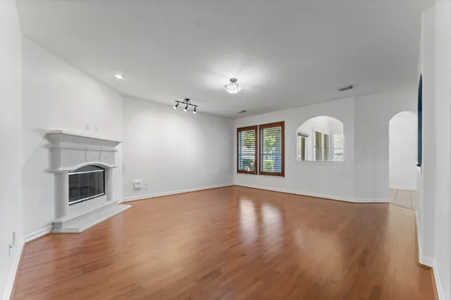 a view of an empty room with a fireplace and a window