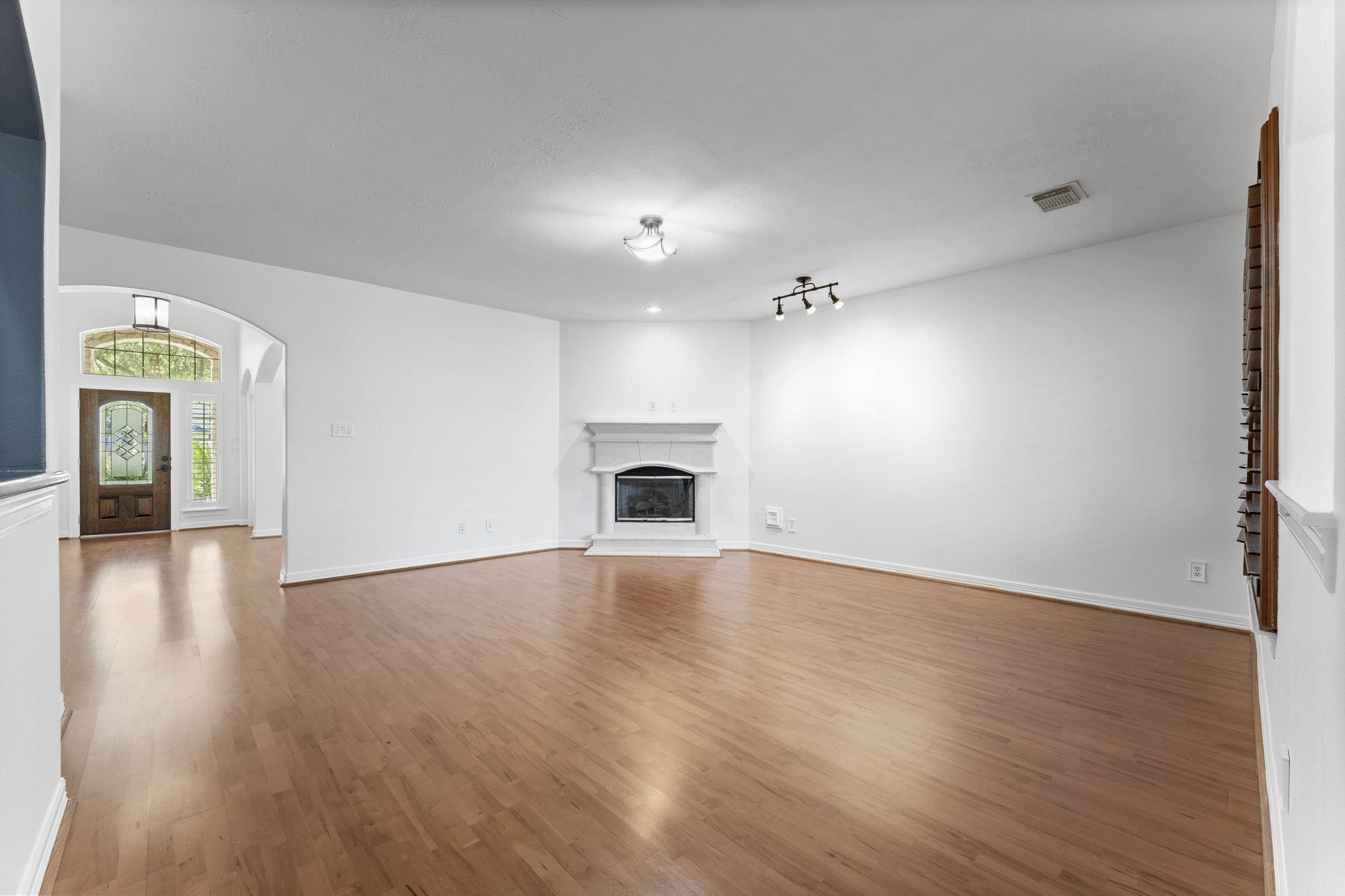 3131 Rustic Gardens Drive Spring, TX 77386 - Photo 9 of 39 a view of an empty room with wooden floor and a fireplace