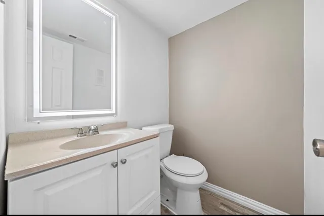 a bathroom with a granite countertop toilet and sink