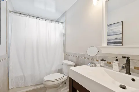 a bathroom with a sink a toilet and a mirror