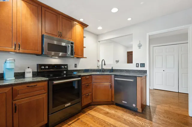 a kitchen with stainless steel appliances granite countertop a stove a sink and a microwave