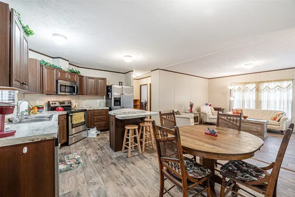 a kitchen with a dining table chairs and refrigerator