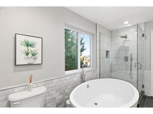 a bathroom with a tub a sink and a large mirror