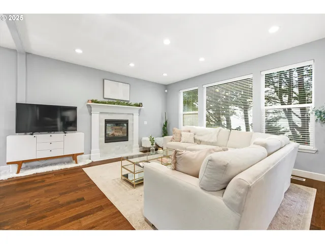 a living room with furniture a flat screen tv and a fireplace