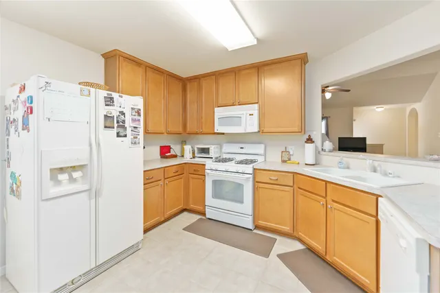 a kitchen with white cabinets and white appliances