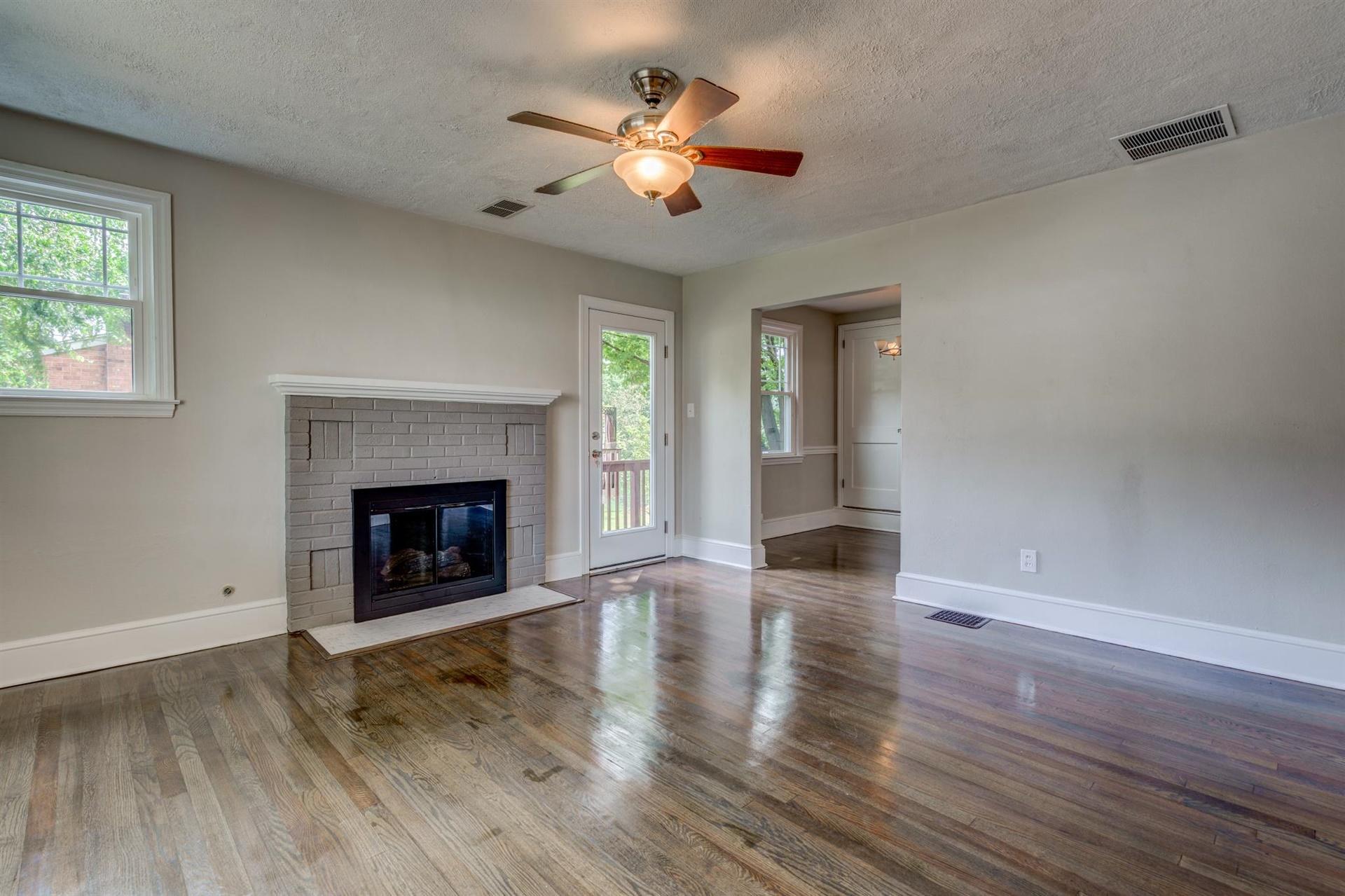 1963 Kiska Road Salem, VA 24153 - Photo 5 of 29 an empty room with wooden floor a chandelier fan a fireplace and windows