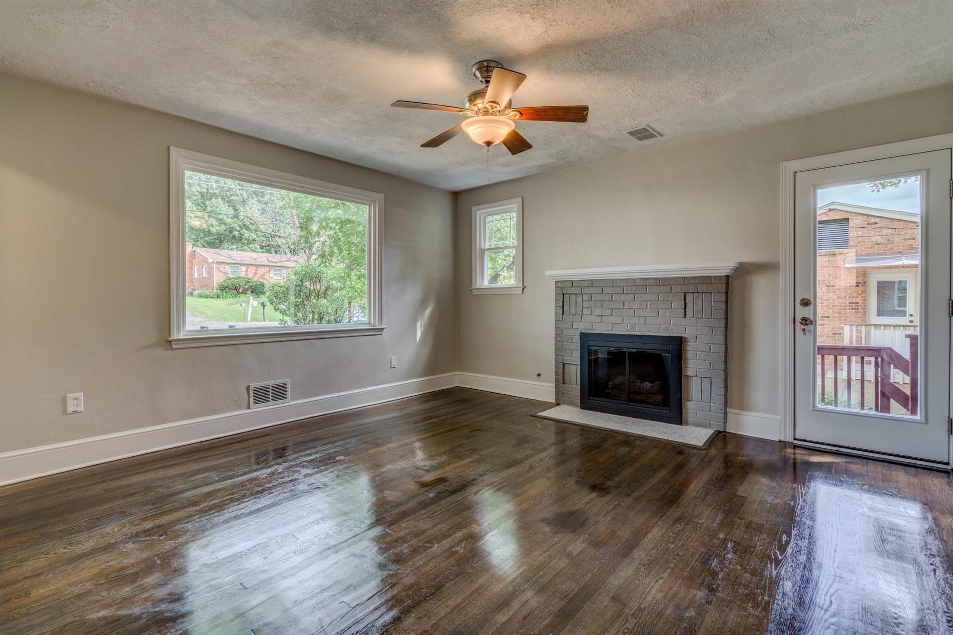 1963 Kiska Road Salem, VA 24153 - Photo 6 of 29 a view of an empty room with wooden floor fireplace and a window