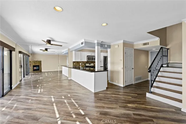 a dining room with wooden floor a chandelier a glass table and chairs