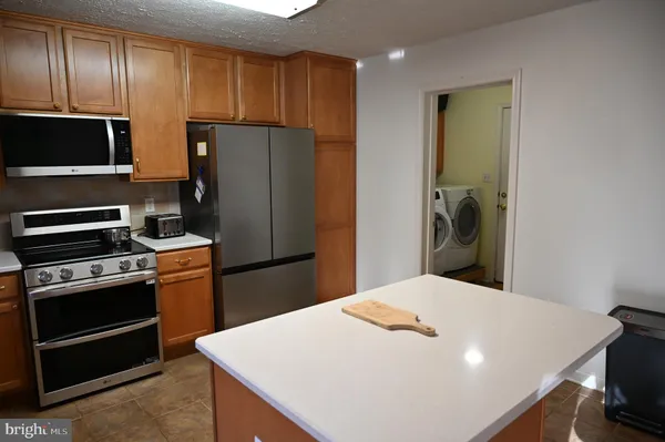 a kitchen with a refrigerator and a stove top oven