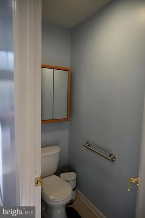 a white toilet sitting in a bathroom next to a sink