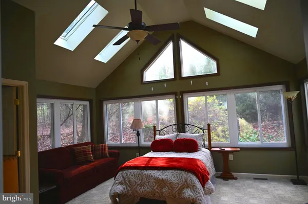 a bedroom with a bed and large windows