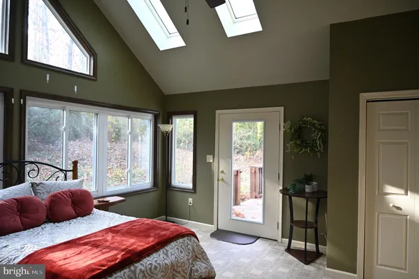 a bedroom with a bed and large windows
