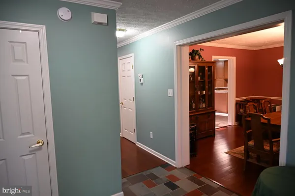 a view of a hallway with wooden floor and furniture