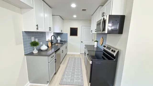 a kitchen with stainless steel appliances granite countertop a refrigerator a stove top oven a sink and dishwasher
