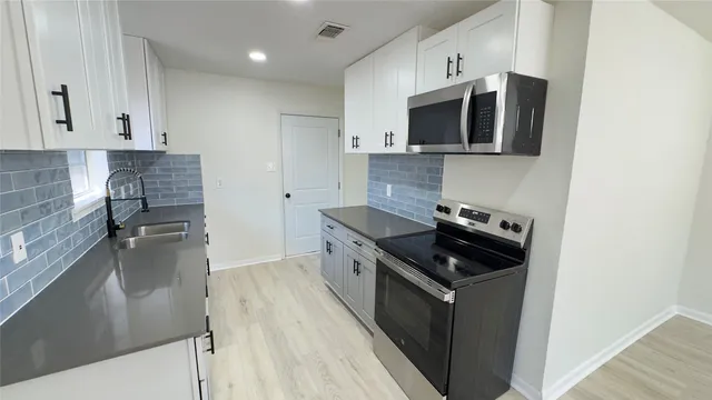a kitchen with stainless steel appliances granite countertop a stove and a sink