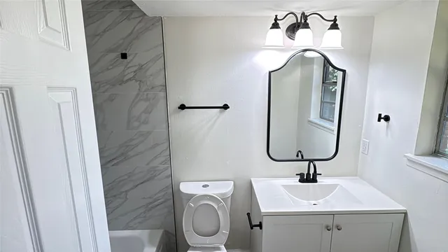 a bathroom with a toilet sink and mirror