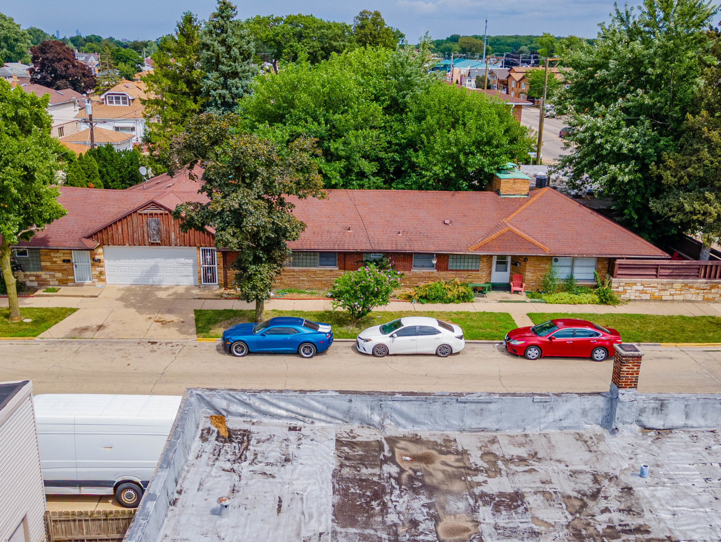 an aerial view of a house with swimming pool and red umbrella