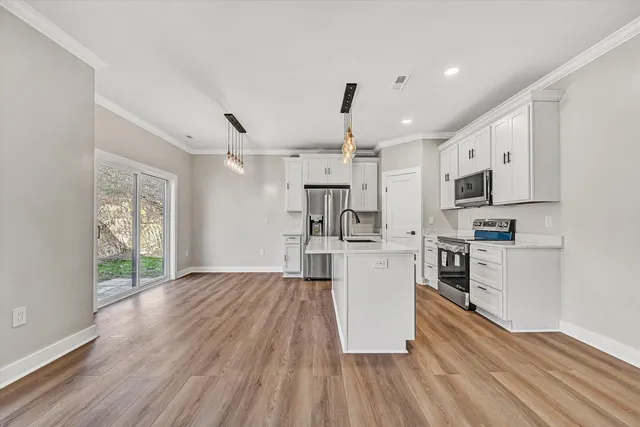 a kitchen with white cabinets and stainless steel appliances