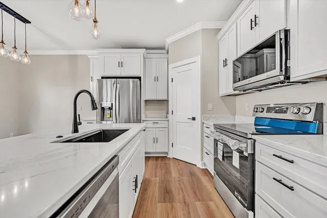 a kitchen with stainless steel appliances granite countertop a sink a stove and cabinets