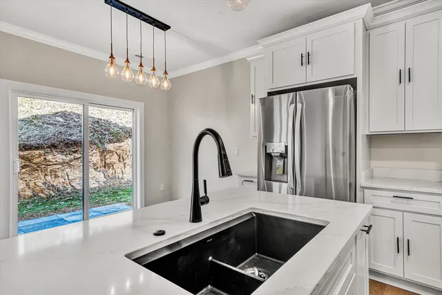 a kitchen with a sink a counter top space and stainless steel appliances