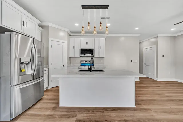 a large kitchen with stainless steel appliances a refrigerator and a stove top oven