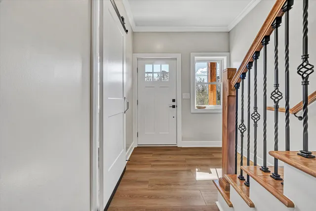 a view of a hallway with wooden floor and staircase