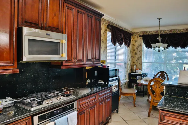 a kitchen with stainless steel appliances a stove a sink and a microwave