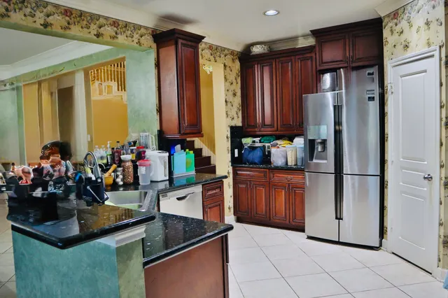 a kitchen with granite countertop a refrigerator and a stove