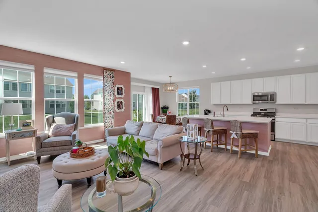 a living room with furniture kitchen and a large window