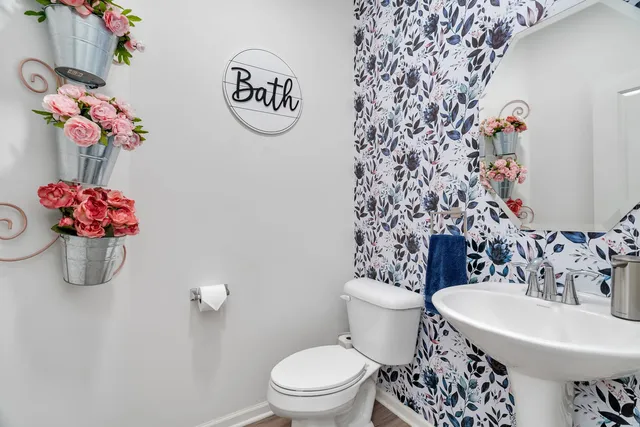 a bathroom with a sink a toilet and a mirror