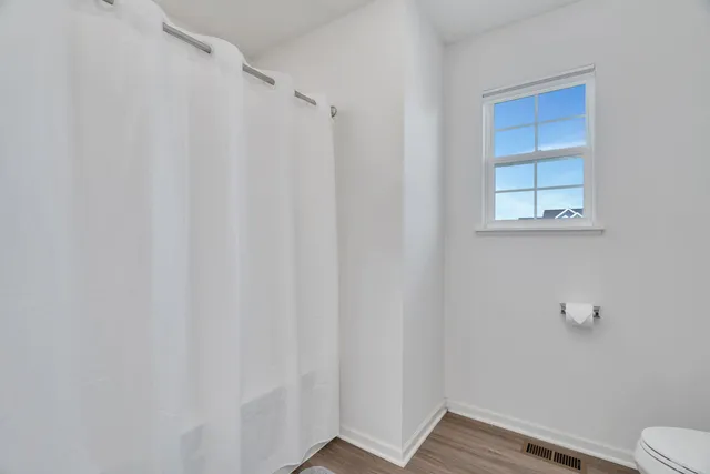 a bathroom with a window and a toilet