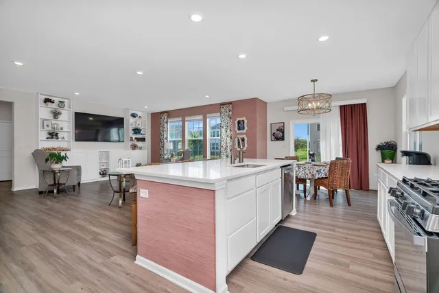 a large white kitchen with lots of counter space and stainless steel appliances