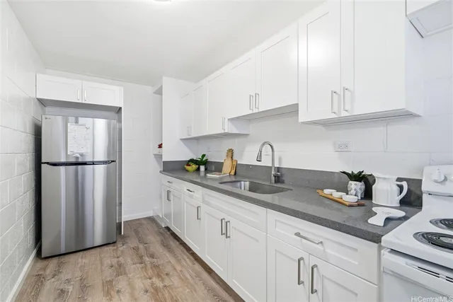 a kitchen with granite countertop white cabinets white stainless steel appliances and sink