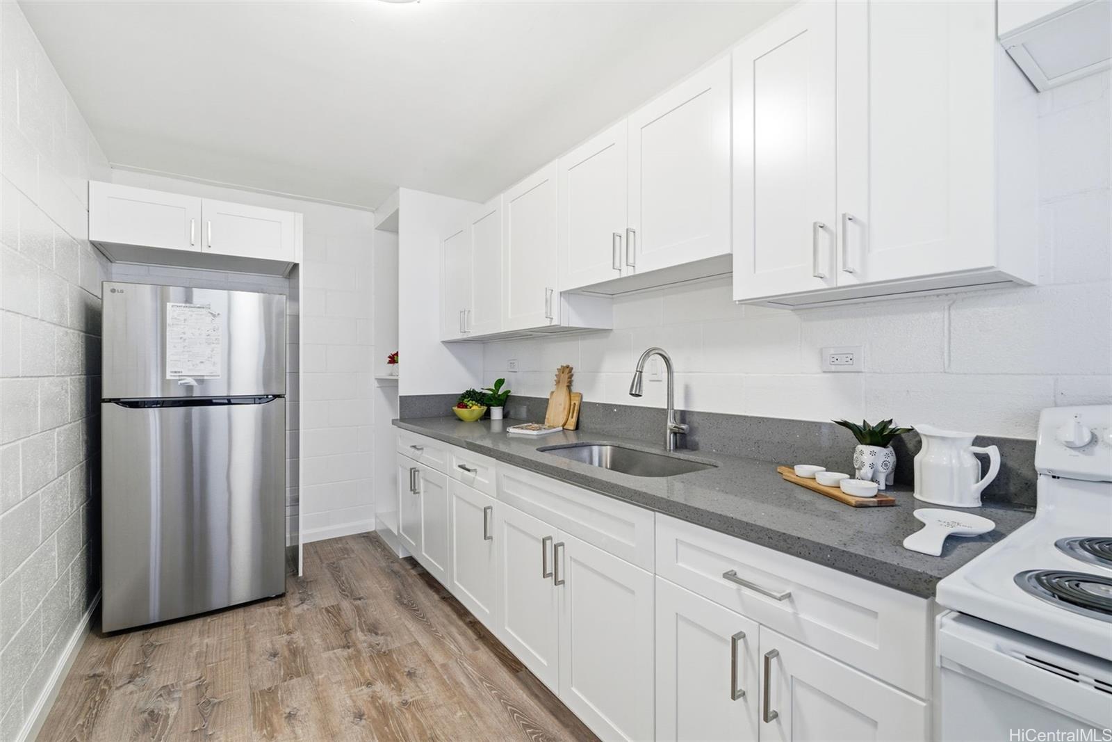a kitchen with granite countertop white cabinets white stainless steel appliances and sink