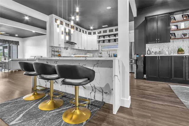 a kitchen with stainless steel appliances a dining table chairs sink and cabinets